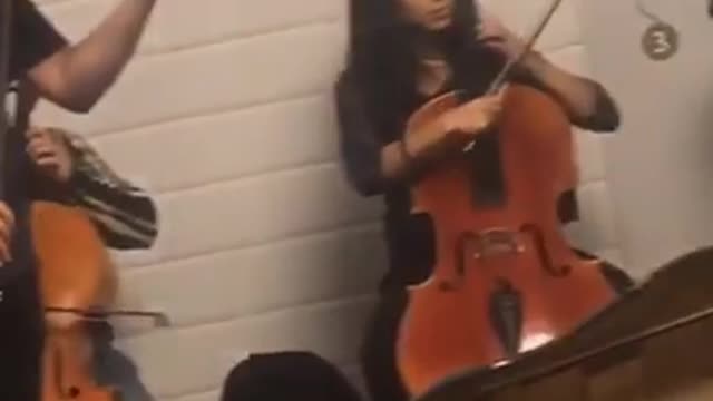 Orchestra in subway violin man sitting on stairs crying cover mouth