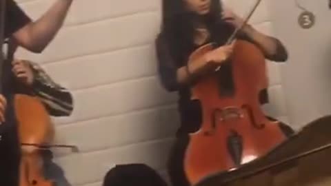 Orchestra in subway violin man sitting on stairs crying cover mouth