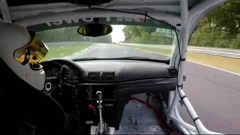 A racing driver drives a racing car.