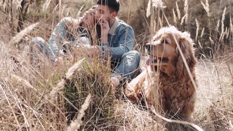 A Couple With Their Dog Seated And Relaxing Outdoor