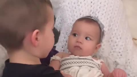 Big brother sweetly kisses his new baby sister