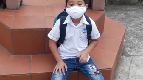 The boy wears a mask to go to school to prevent covid-19.