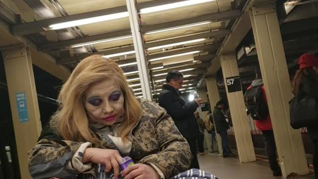 Woman puts on a lot of makeup and looks like a clown, subway station