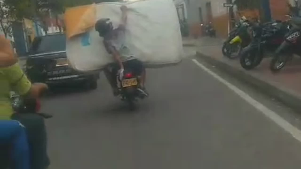 Motociclista transporta colchón en una moto