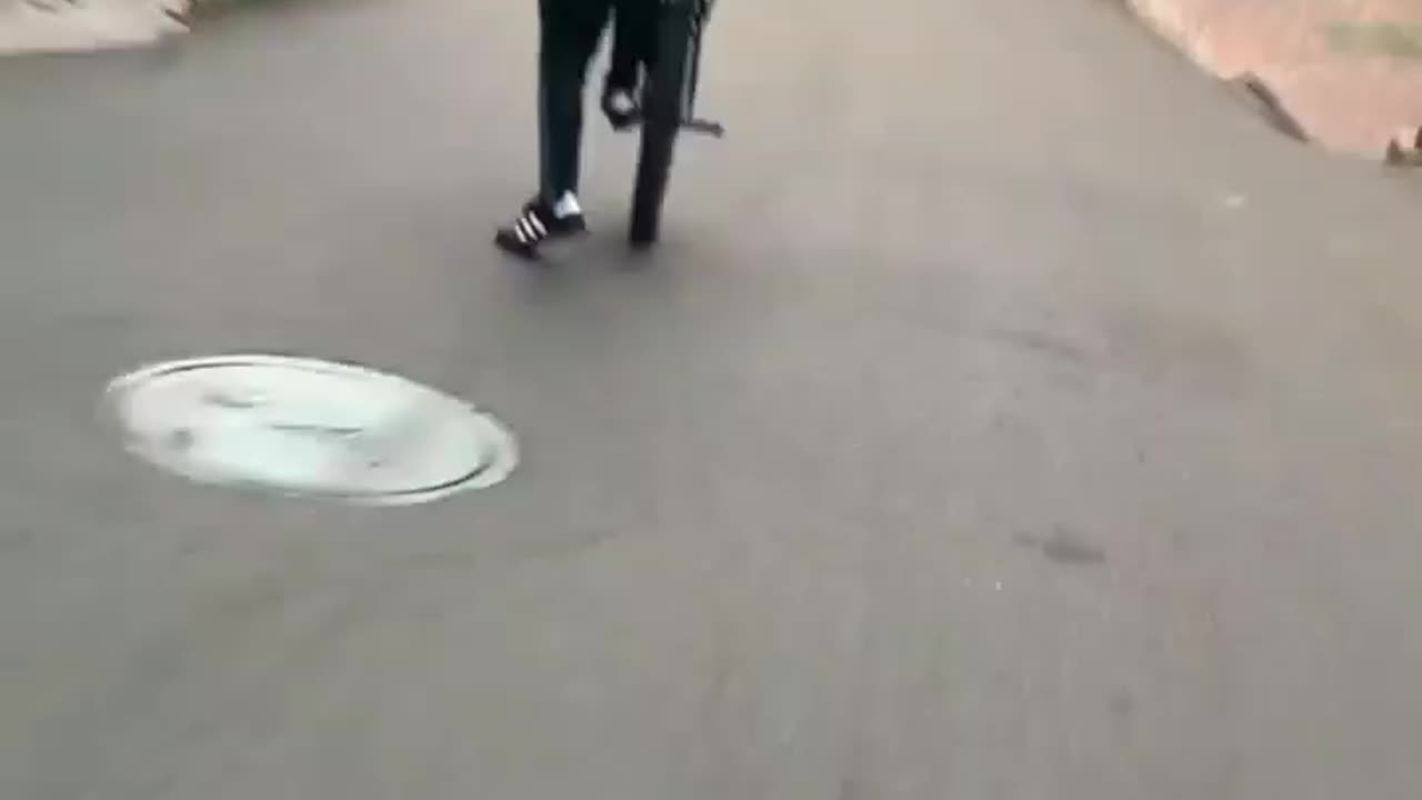 idiot rides down hill on one wheel and hits motorbike rider head on