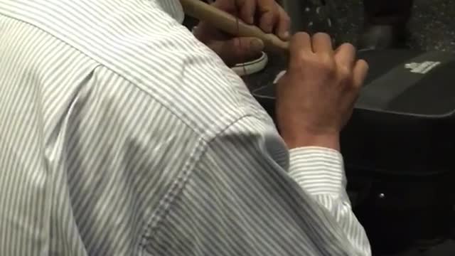 Man plays brown flute in subway