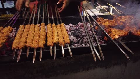 A Person Grilling Meat In The Street