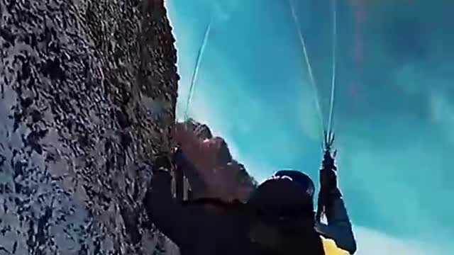 Paraglider flying on snowy mountains