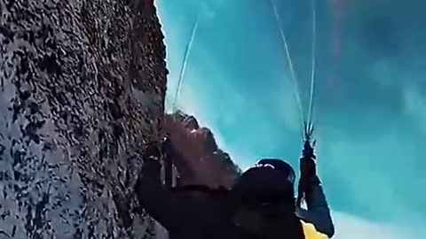 Paraglider flying on snowy mountains