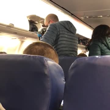 Woman wears ski gear on airplane