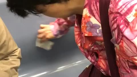 Woman in pink cleans subway chair