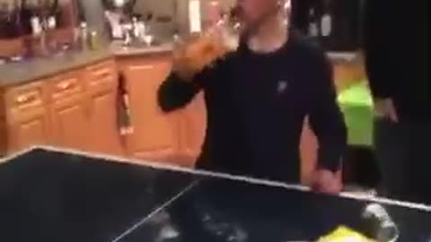 Guy black shirt drinking fireball and hitting it against pingpong table