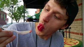 Kid with split tongue eats ice cream in bizarre fashion