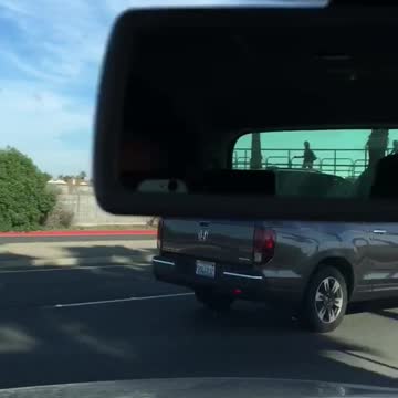 Guy carries longboard standing up in truck bed