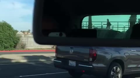 Guy carries longboard standing up in truck bed