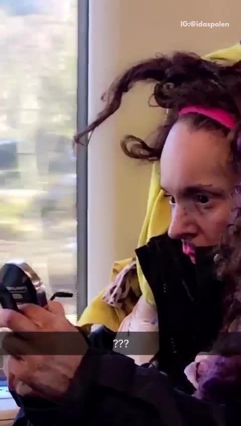 Guy purple hair pink bandana putting on pink lip gloss