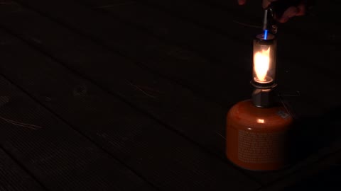 Light a lantern at night at a camping site.