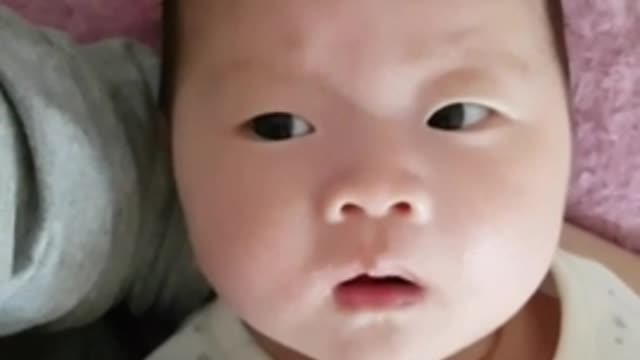 The baby is staring at his mother