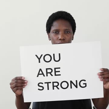 A Woman Holding A Motivational Poster