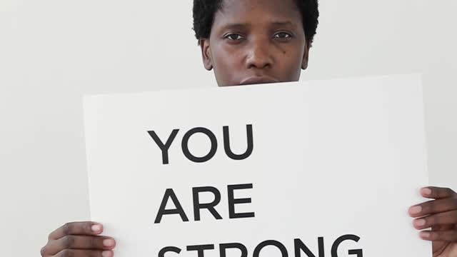 A Woman Holding A Motivational Poster