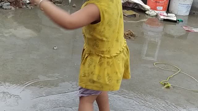 Girl playing on the terrace in the rain.