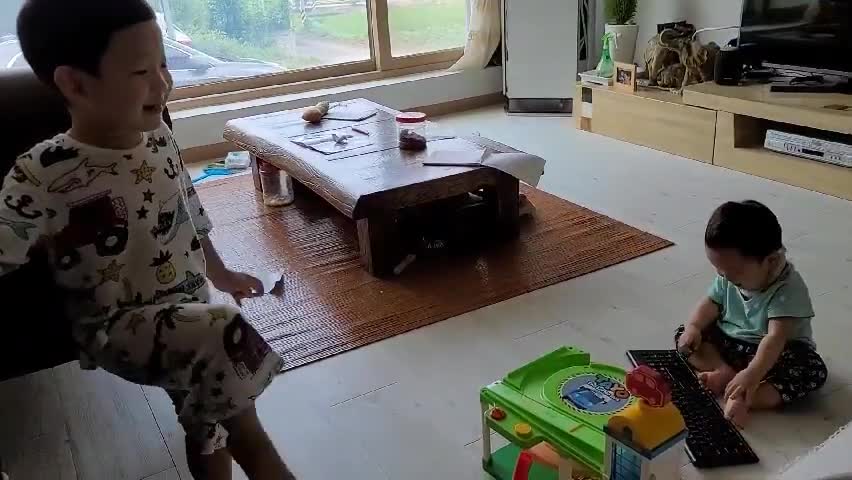 This is a video of two babies playing with a toy rocket.