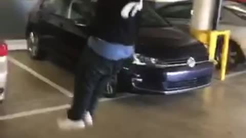 Black t shirt and jeans guy tries to hang from pipe in garage and falls on back loses glasses