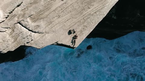 Men take selfies using drones on cliffs by the sea