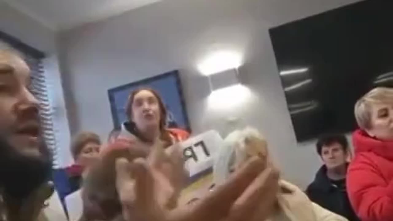 man in military uniform tells Ukrainian women about the difficult situation at the front