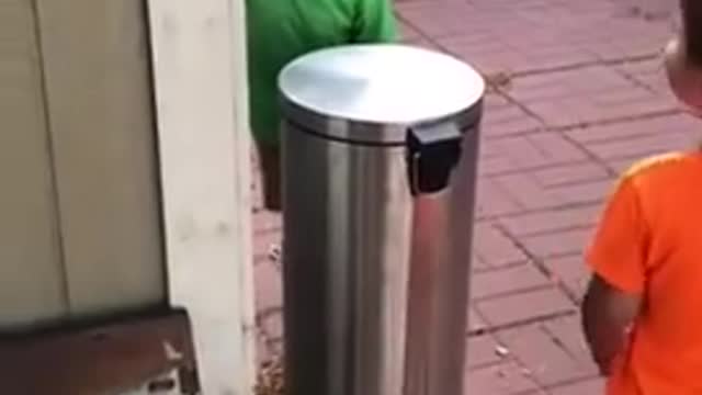 kids jokingly hit each other with trash can's