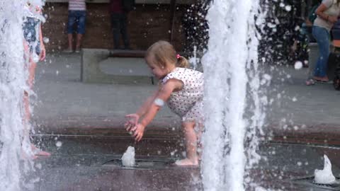 kids playing with the water fountain