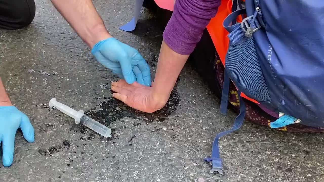 Insulate Britain protestors glue their hands to the road to stop themselves from being removed