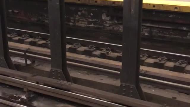 Man in green vest with lawnmower on subway station