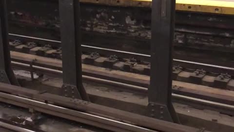 Man in green vest with lawnmower on subway station