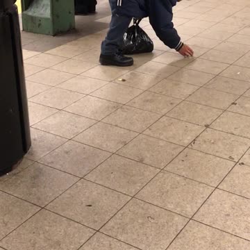 Man blue outfit scratching and tapping floor subway