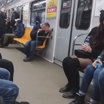 Drunk guy on subway train falls down into his seat and looks dazed