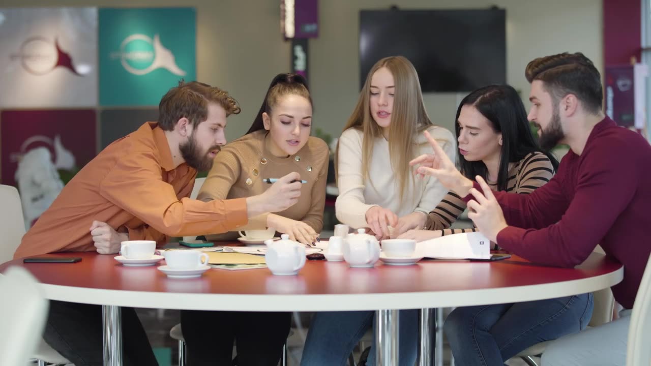 Students in a cafeteria discussing an assignment