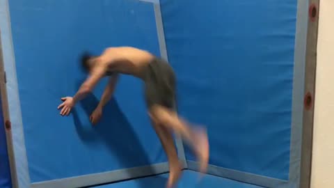 Guy does front flip on gym safety mat and falls