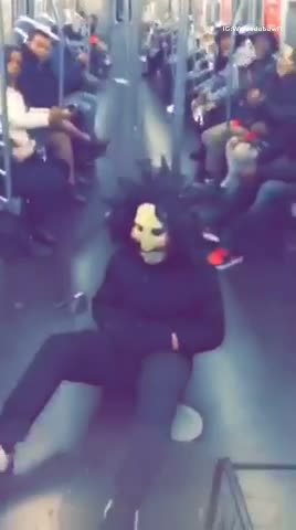 Man sitting in subway floor dressed as doll from saw movies