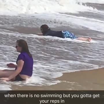 Kid practicing surfing on sand as wave comes in