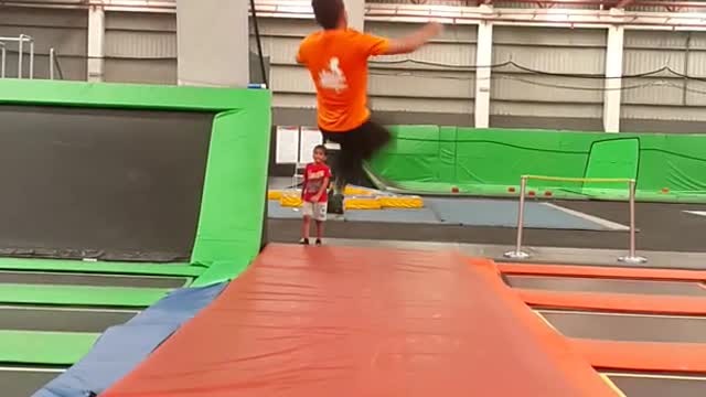 Guy in orange failed back flip in trampoline park