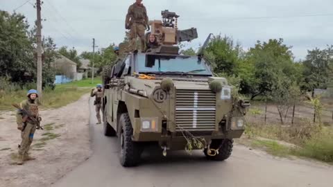 Fallschirmjäger der 80 dshb auf dem australischen Schützenpanzer "Bushmaster" im befreiten Dorf.