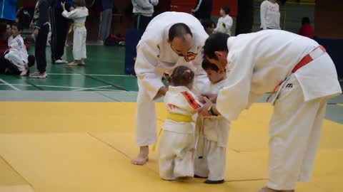 Funny little girl and boy judo fight