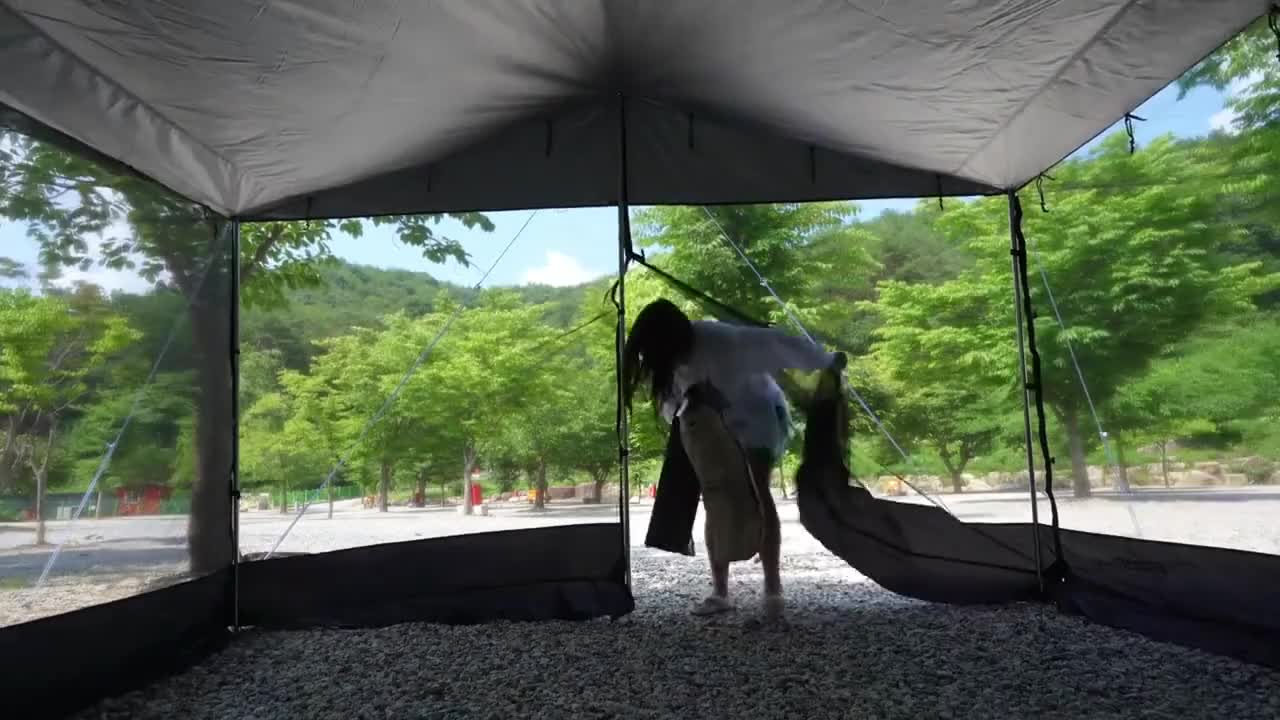 Outdoor camping, tent under the tree when the weather is too hot to enjoy cool food