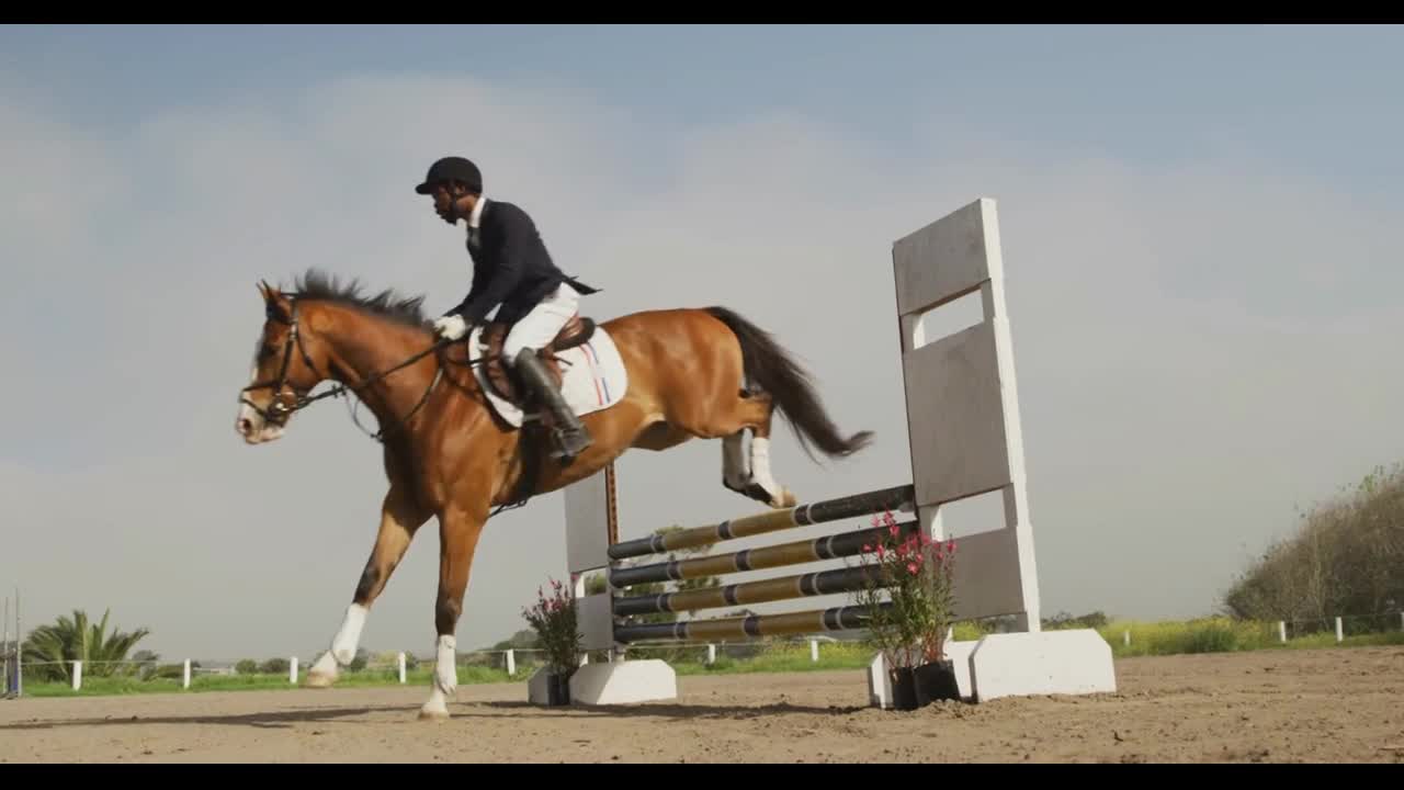 African American man jumping an obstacle with his Dressage horse