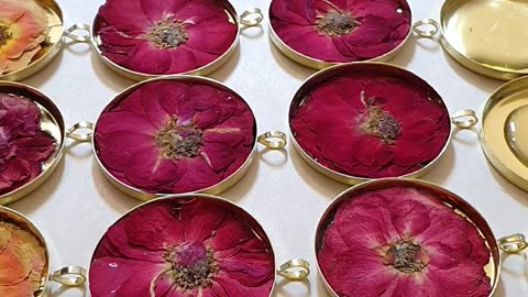 making 40 resin necklaces at the same time, with pressed miniature roses