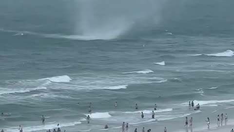 Waterspout ripping through crowed beach