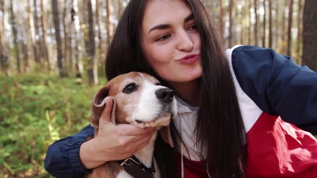 Girl walk about with beagle puppy in autumnal park