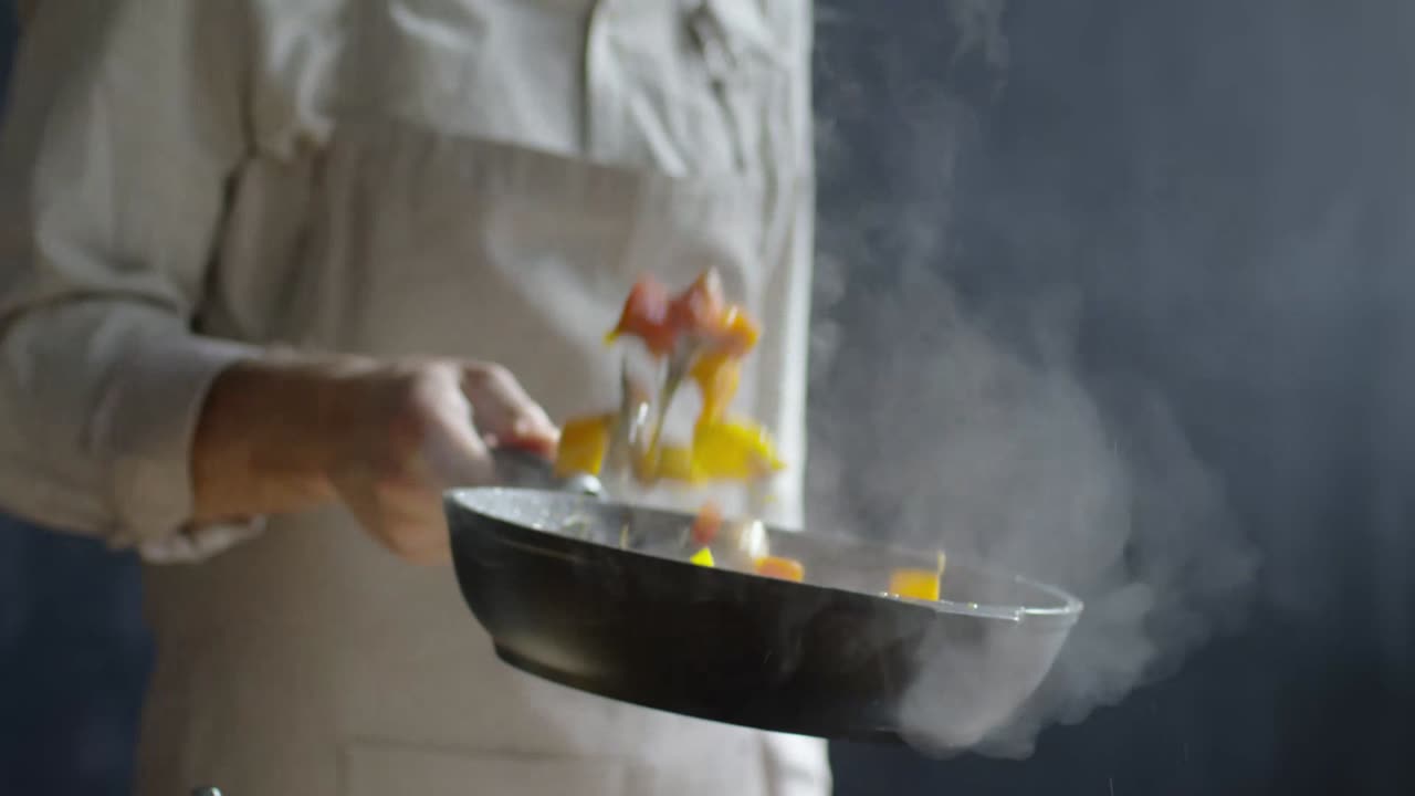 Close up of unrecognizable chef tossing chopped vegetables from a pan | itsaliraza