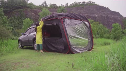 A man cooks outdoors in the rain